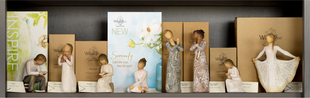 Willow Tree hand carved figurines displayed on a shelf next to a sign with the word LOVE